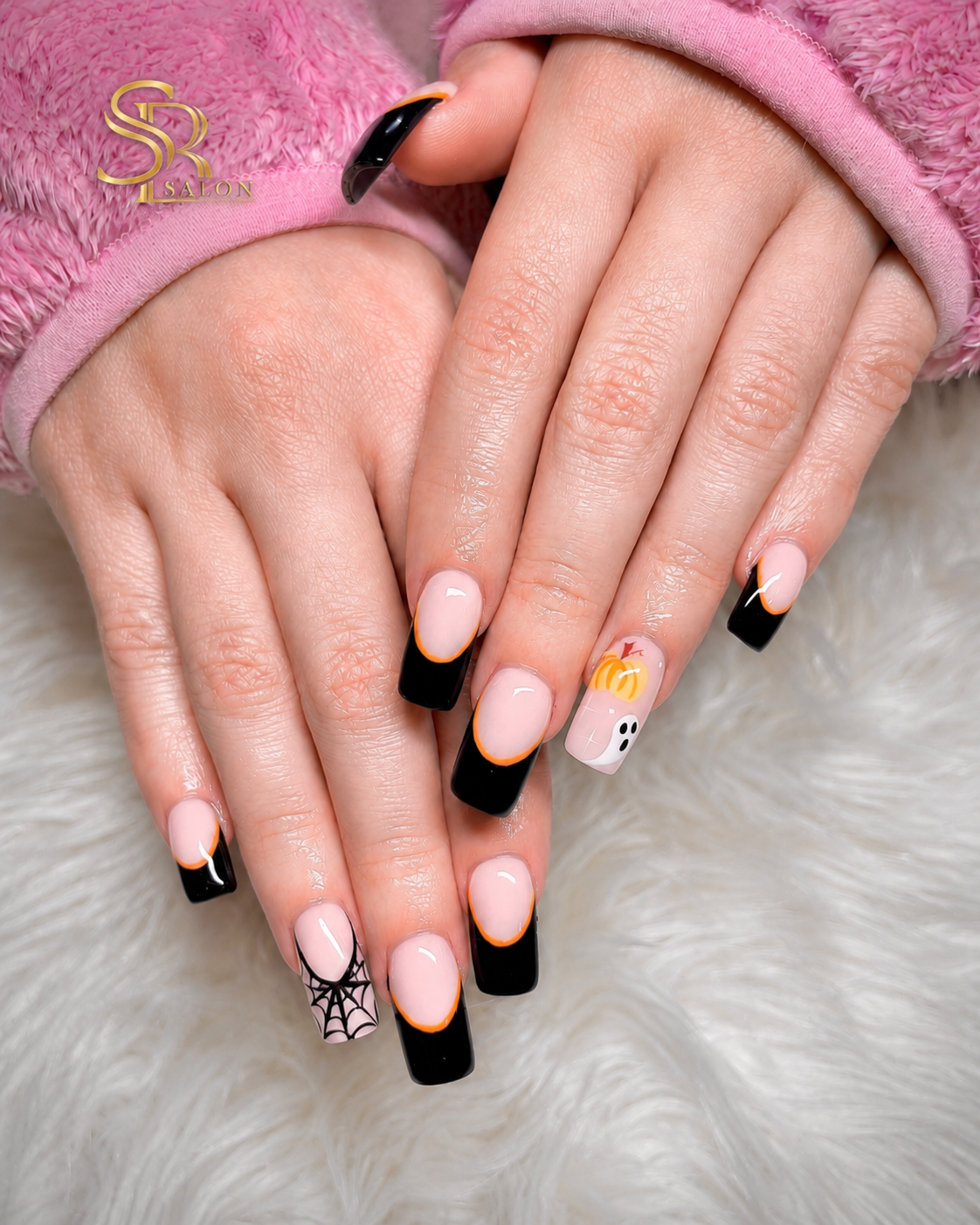 Square nails with black and orange French tips, spider web art, pumpkin and ghost Halloween nail art.