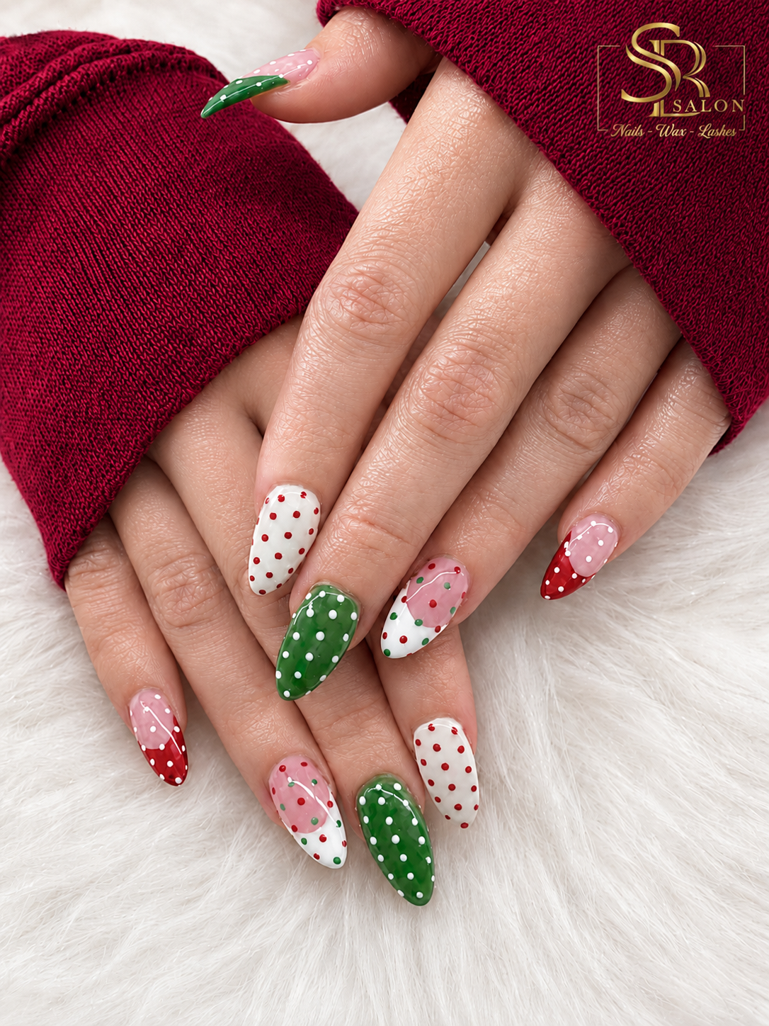 Almond nails with red, green, and white Christmas polka dot nail art.