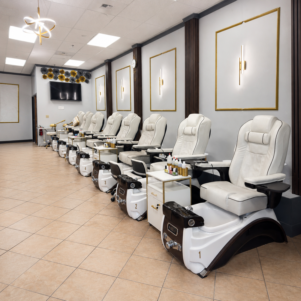 Row of luxury white pedicure spa chairs with gold hardware inside SB Salon.