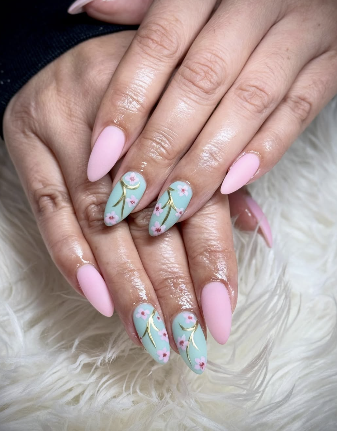 Pastel pink and mint nails with delicate blossom artwork and fine gold detailing.